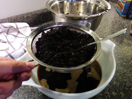 Use a sieve to get the big chunks.  It's best to get the big chunks first so they don't clog up the paper filter.
